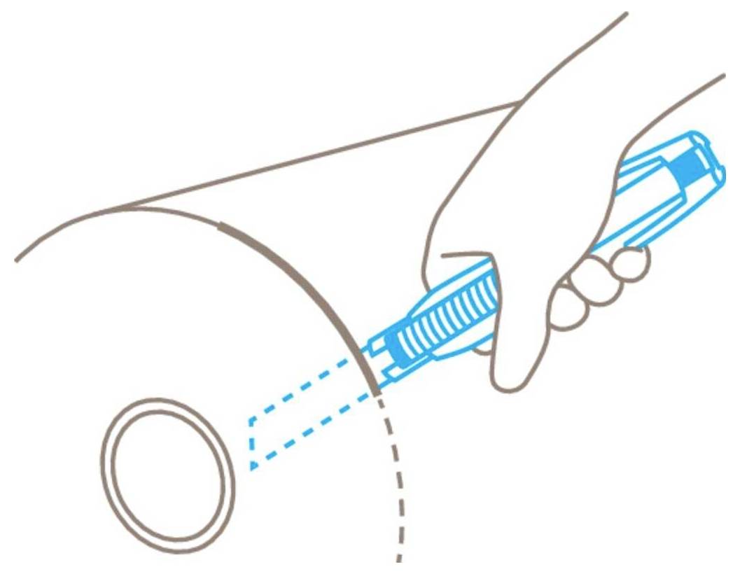 A hand holds a blue tool, cutting along a line on a circular surface.