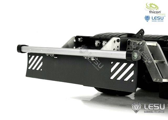 Close-up of a grey bumper with a silver tube and mounted metal grille. Brand logos are located in the top right corner.