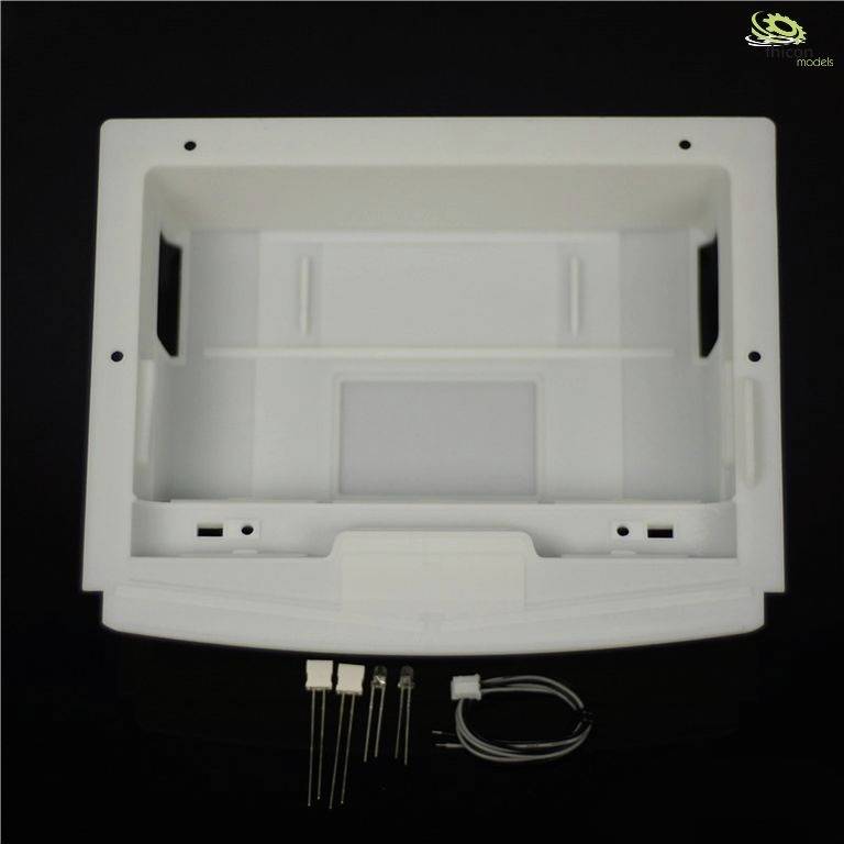 A rectangular, white plastic frame with two handles on the sides. Underneath are two plastic bolts and a cable with a plug.