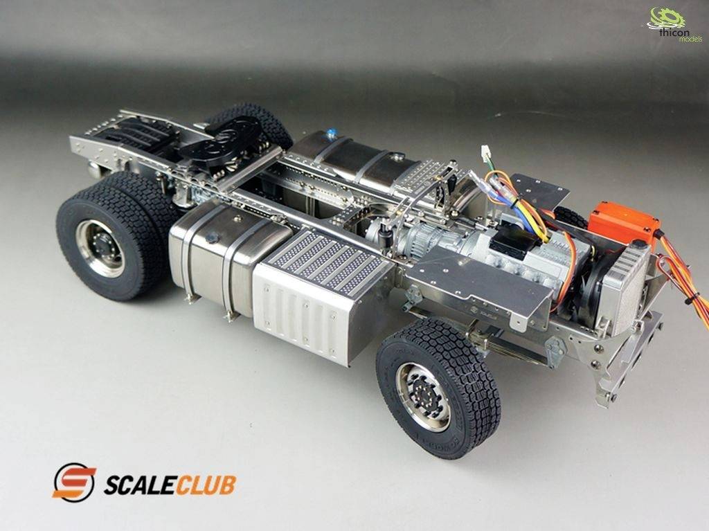 Model vehicle without bodywork on a grey background. The frame, wheels, and several technical components are visible.