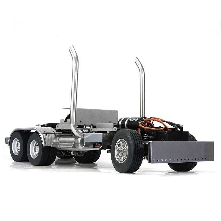 An incomplete lorry with visible chassis, two rear axles, exhaust pipes, and exposed cables. No cab or cargo area.