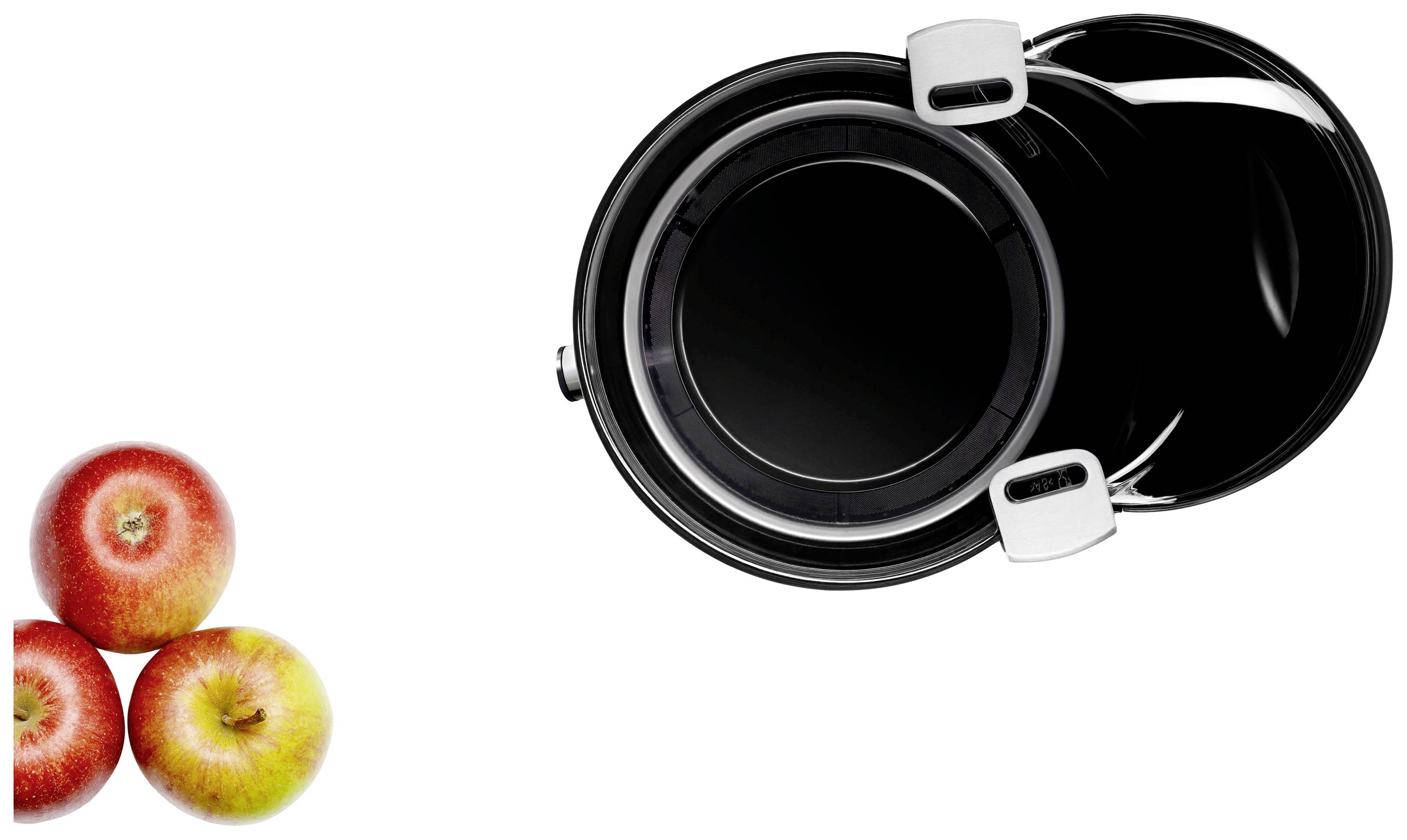 Three apples beside a black cooking pot with a silver handle, viewed from above.