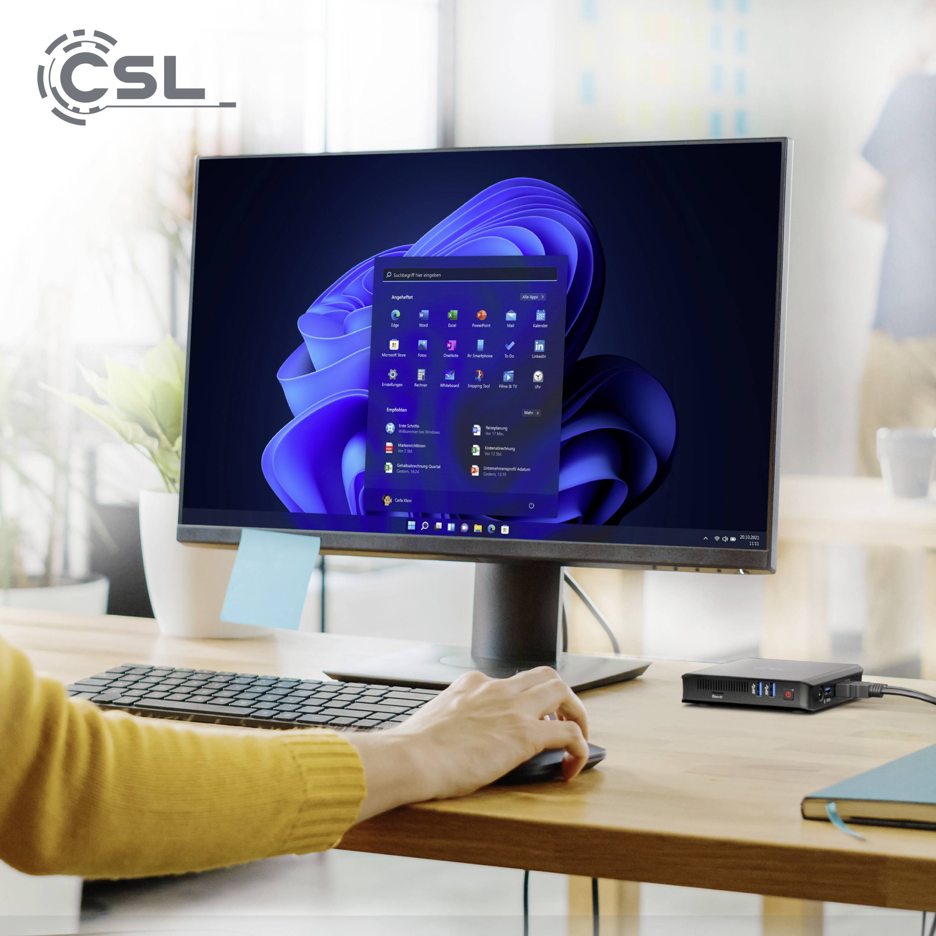 A person is working on a computer with a Windows desktop. A USB hub is sitting next to the keyboard on a desk.