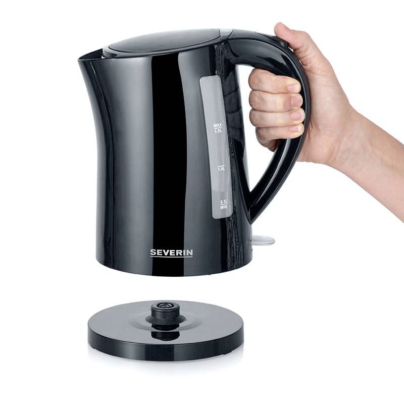 A black kettle on a white background, with the base removed. A hand is holding the kettle.