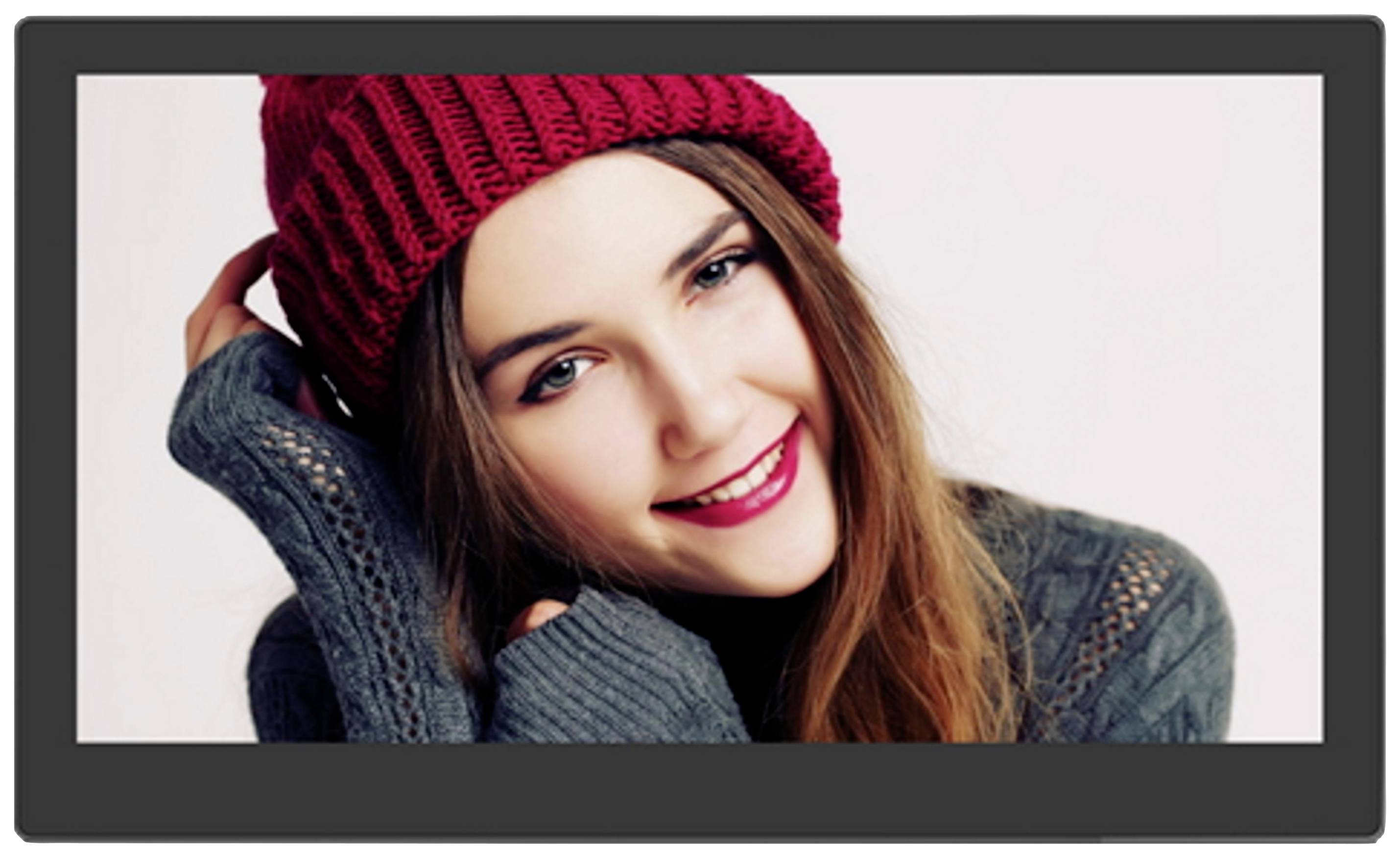 A smiling person is wearing a red hat and a grey jumper. They are looking directly at the camera.