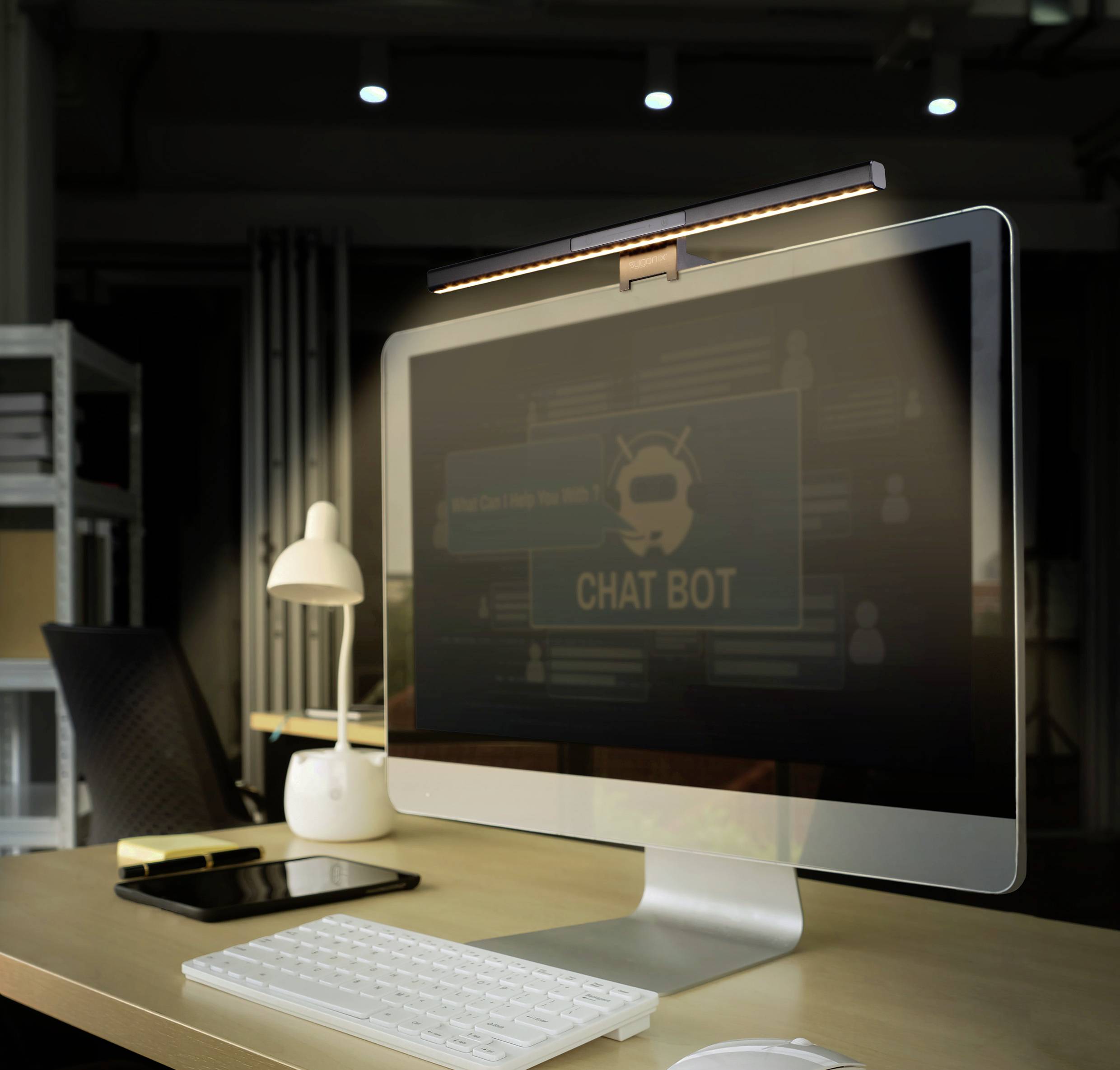 A desk with a computer displaying a chatbot interface. Bookshelves and electronic equipment are visible in the background.