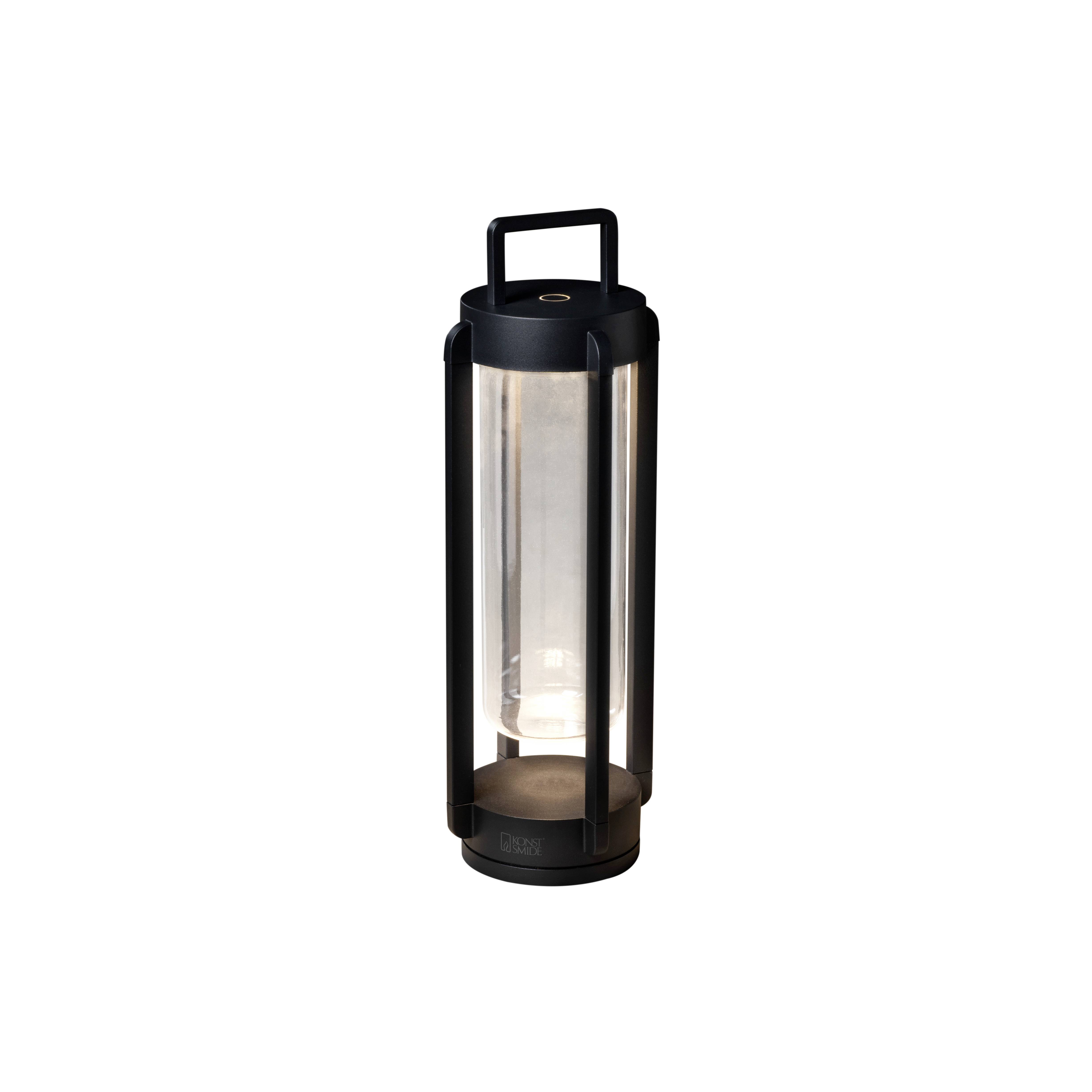 Black portable lantern with smooth casing and handle, emits soft light. Suitable for indoor and outdoor use.