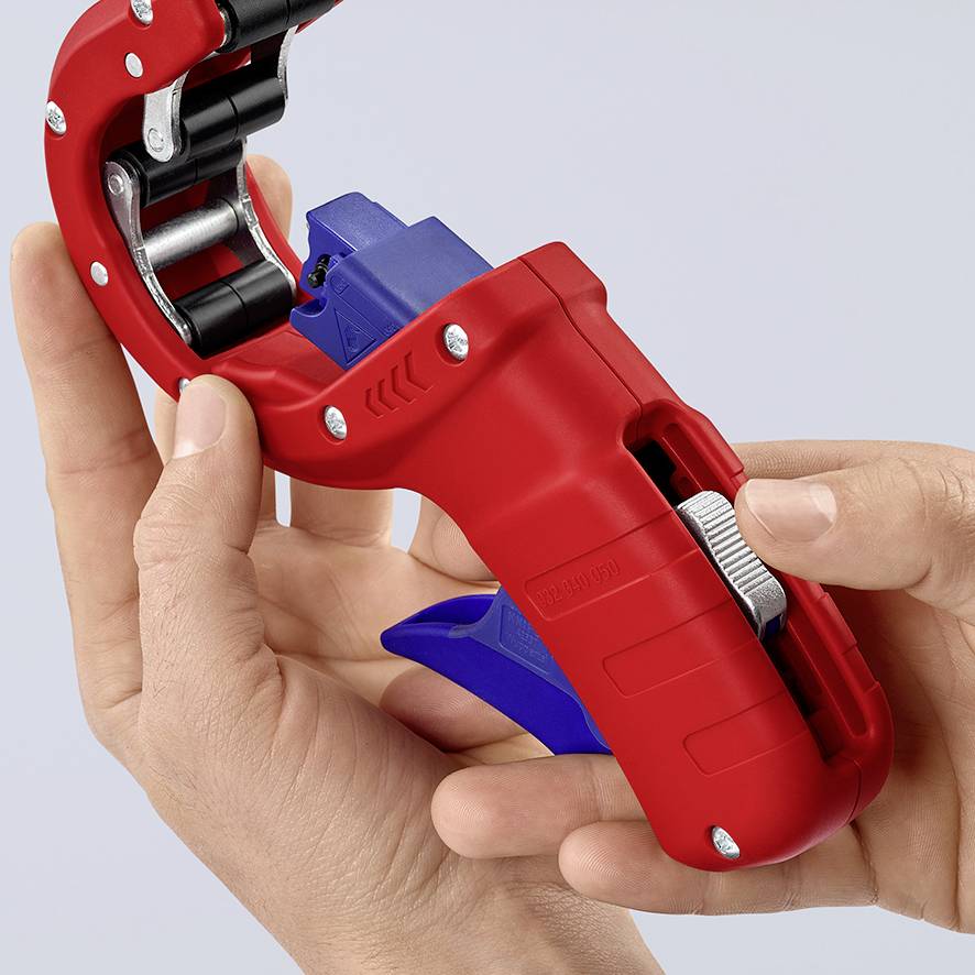 A hand holds a red tape dispenser, fitted with a blue handle and ready to dispense tape.