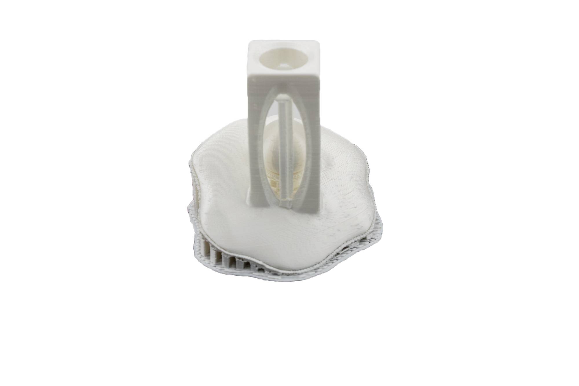 A white 3D-printed object resembles a round base with a tower-like element in the centre.