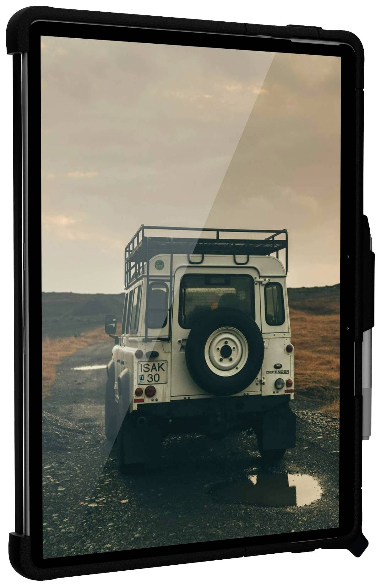 An off-road vehicle drives along a muddy track through a rural landscape, while the sky is overcast.