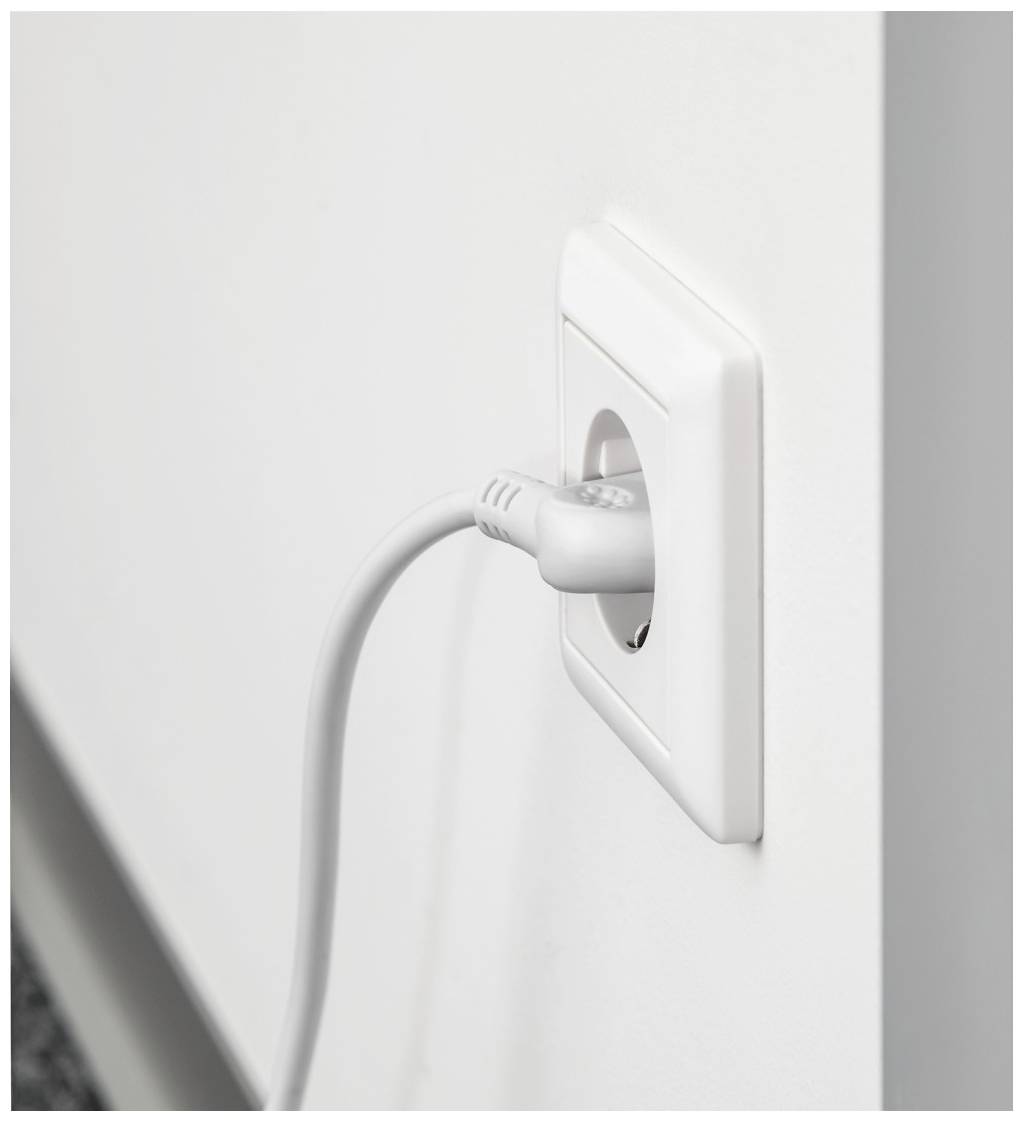 A white wall socket with a grey power cable plugged in. The cable runs downwards, the wall is light and smooth.