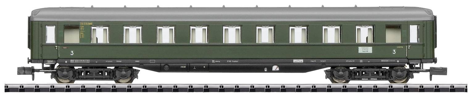 Green historic railway carriage, side view with multiple windows. Standing on railway tracks.