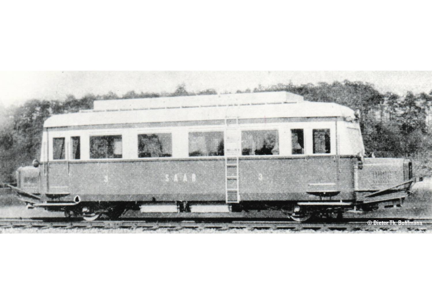 An old railbus with the inscription 'Saar' on a track, surrounded by trees in the background.