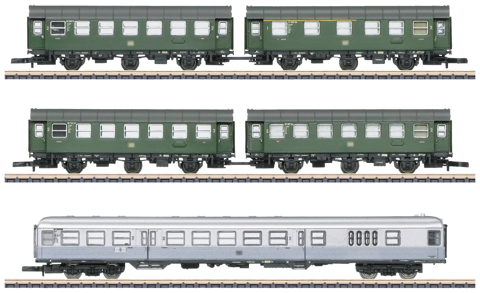Four model railway carriages, three green and one silver, displayed on tracks.