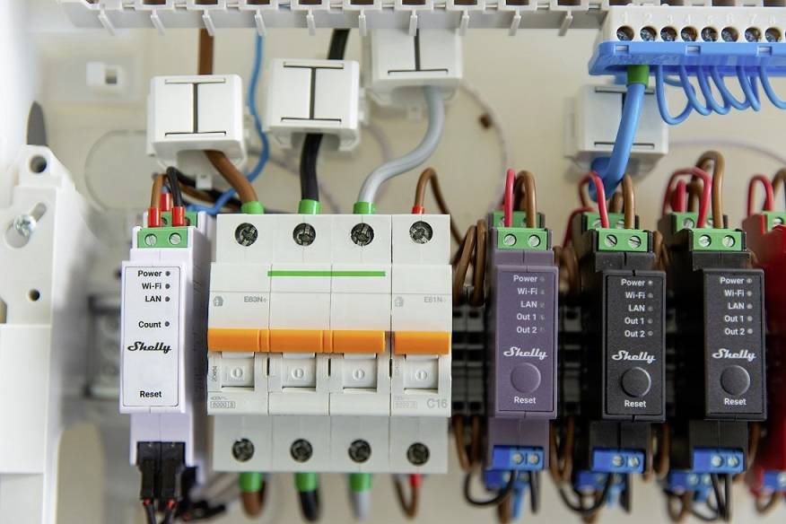 Close-up of a fuse box with multiple switches and cables. Labels on the modules: Power, LAN, Reset.
