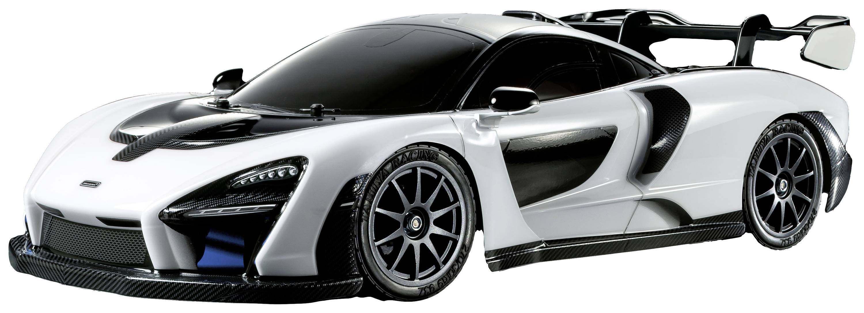 A white sports car with a black roof and accents, aerodynamic design and large rear spoiler, stands against a grey background.