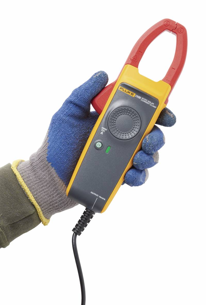 A gloved hand is holding an electrical clamp meter adapter with a yellow and red casing, ready for current measurement.
