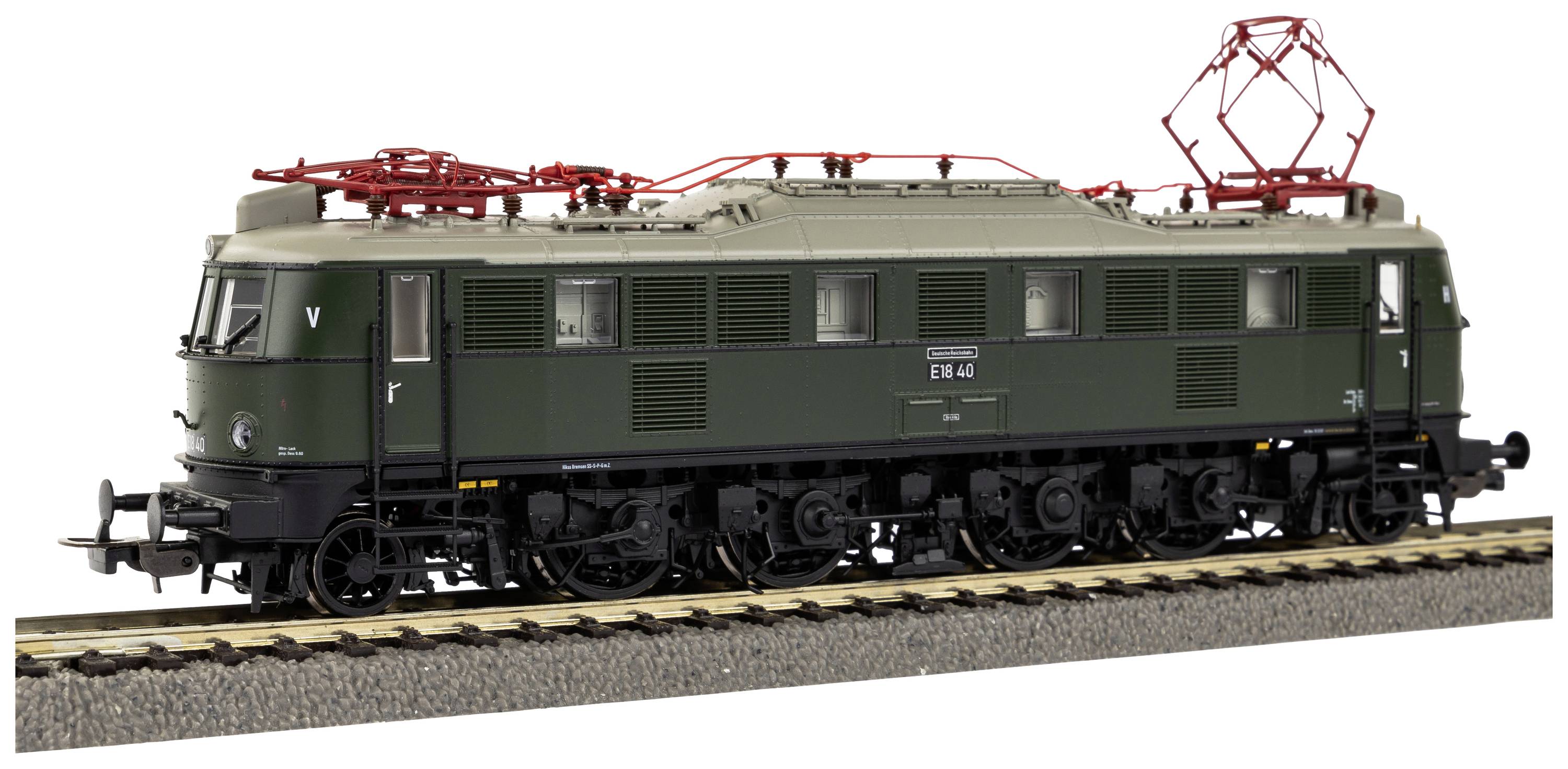 A green model of an electric locomotive is standing on a track. The locomotive has a red pantograph system on its roof.