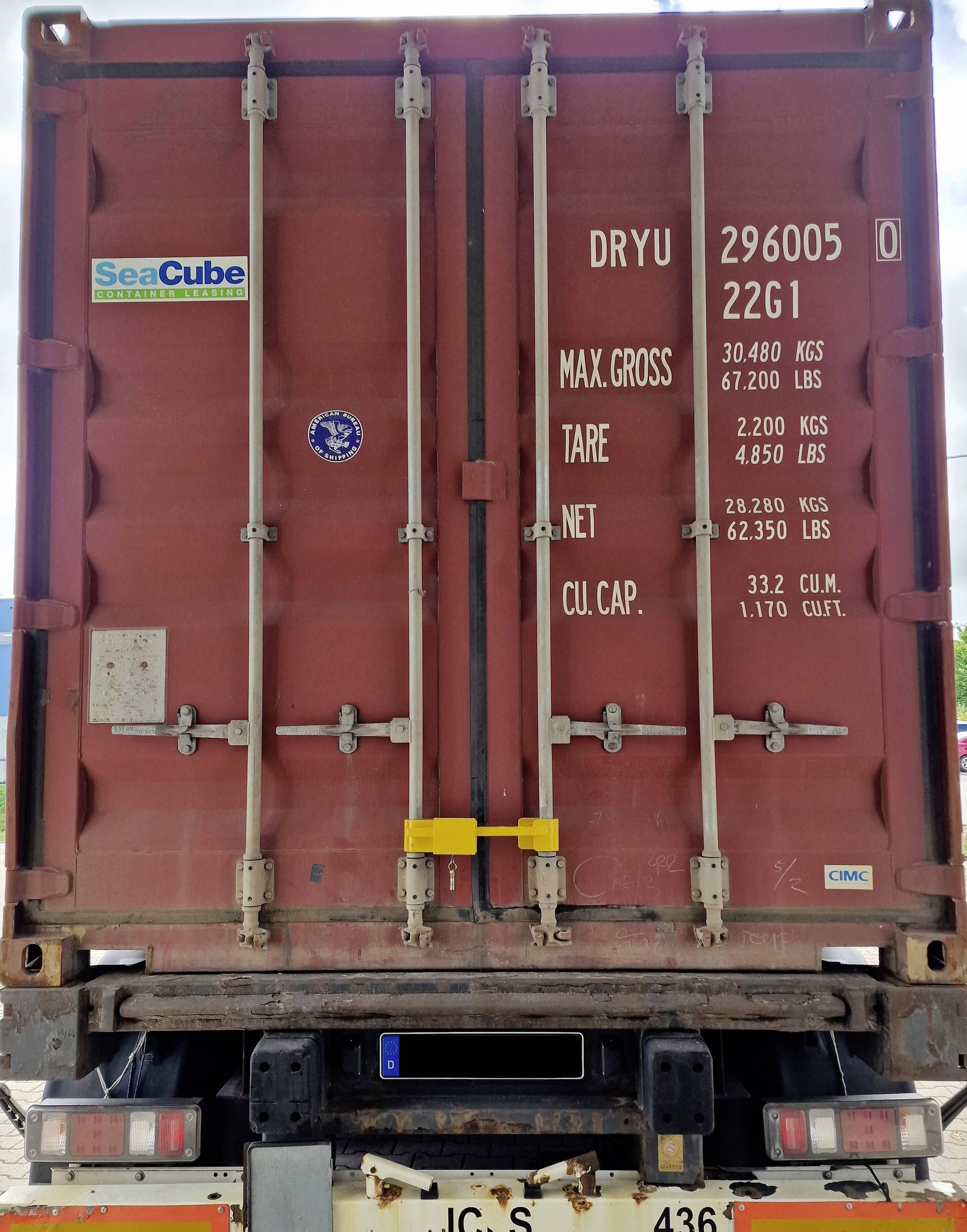 A red container door with writing about weight data: MAX. GROSS 30,480 KGS, TARE 2,220 KGS, NET 28,260 KGS, CU. CAP. 33.2 CUM.