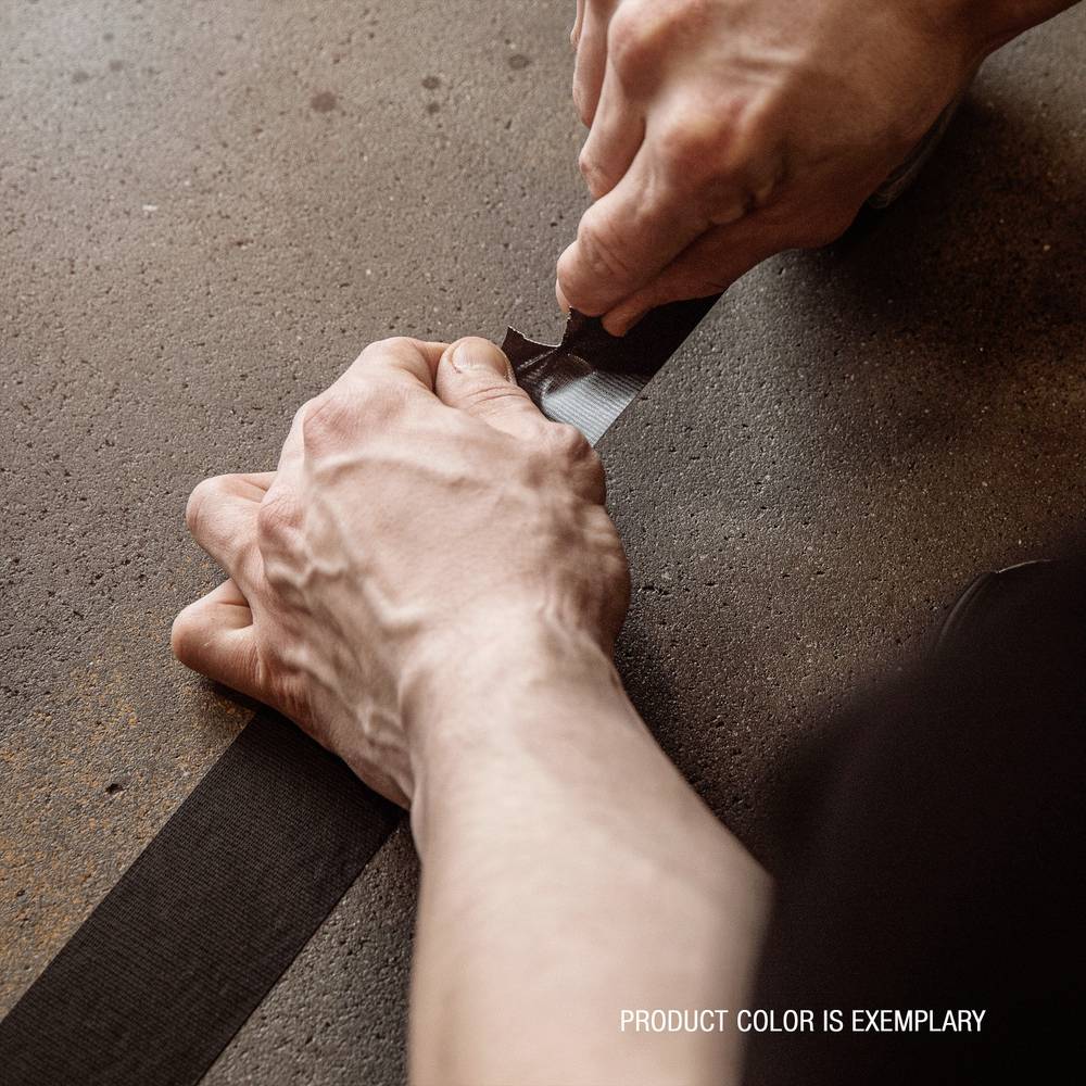 Two hands are stretching black adhesive tape taut across a brown surface. The text in the corner reads 'Product colour is exemplary'.<br><br>Note: I changed 