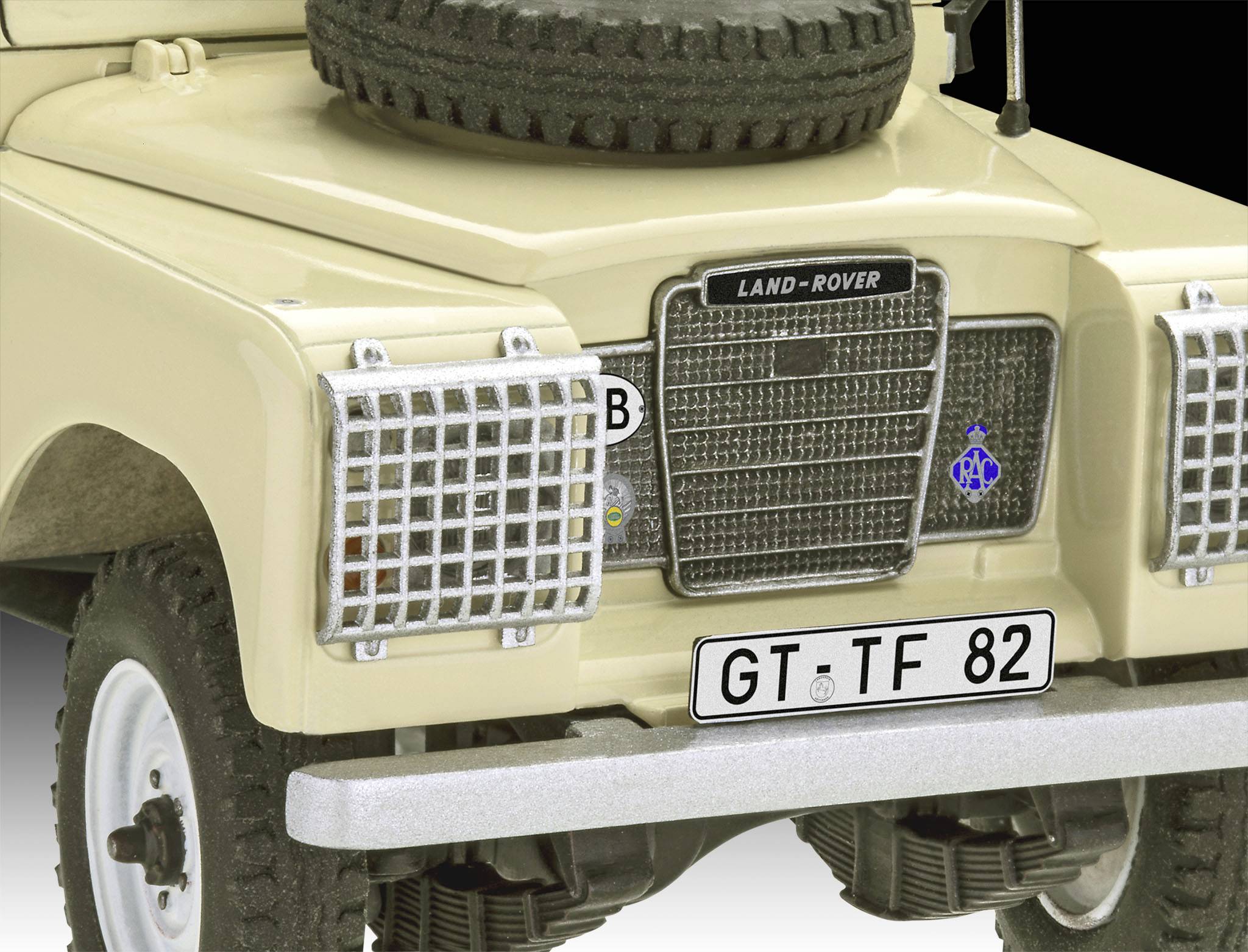 A beige Land Rover with a spare wheel mounted on the bonnet. The number plate reads 'GT TF 82'. The vehicle is stationary.