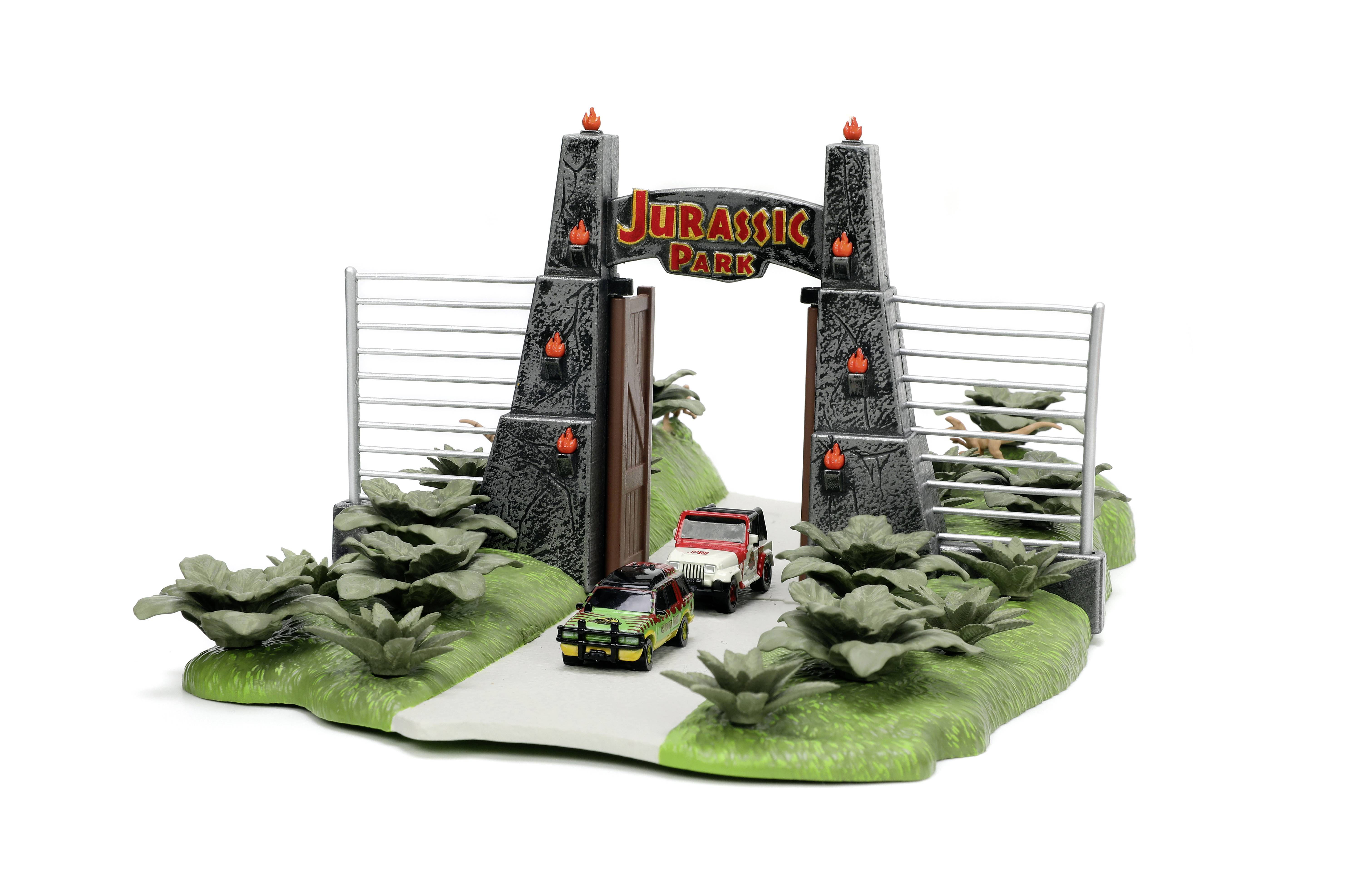 Miniature model of the 'Jurassic Park' gate with two vehicles on a road, surrounded by plants and fences.