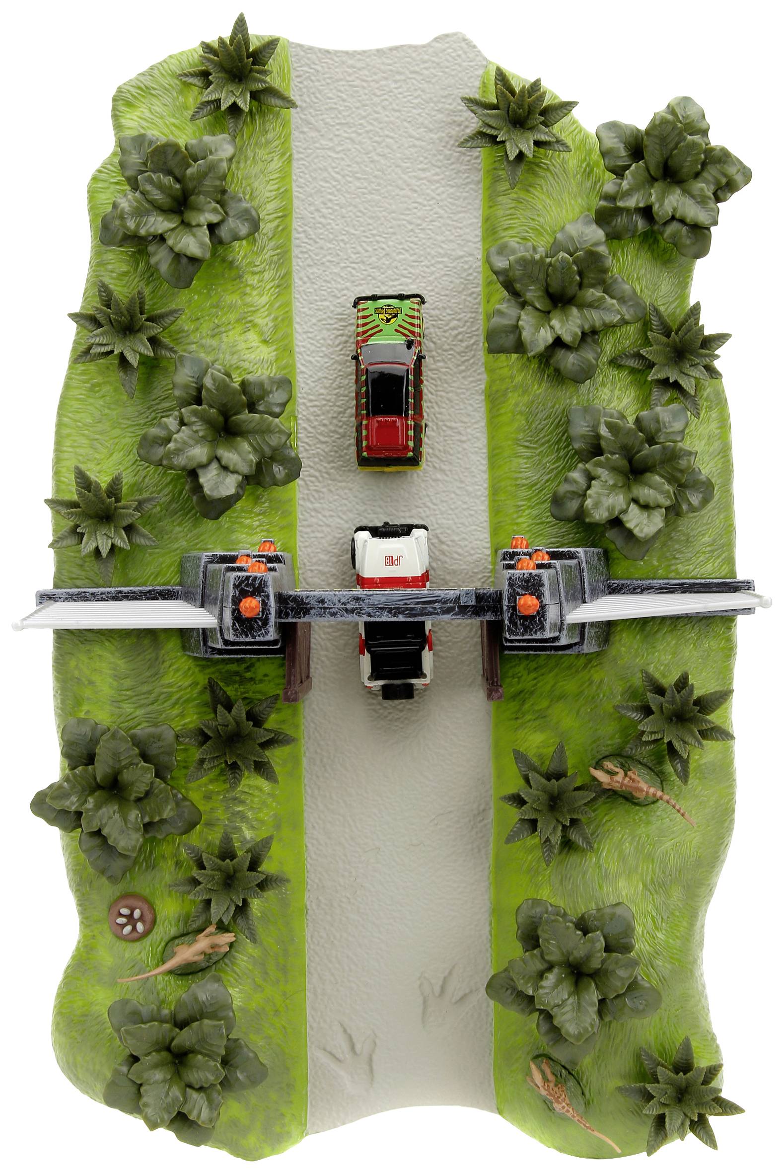A toy car drives through a narrow street between green plants and trees, with barriers and other small details.