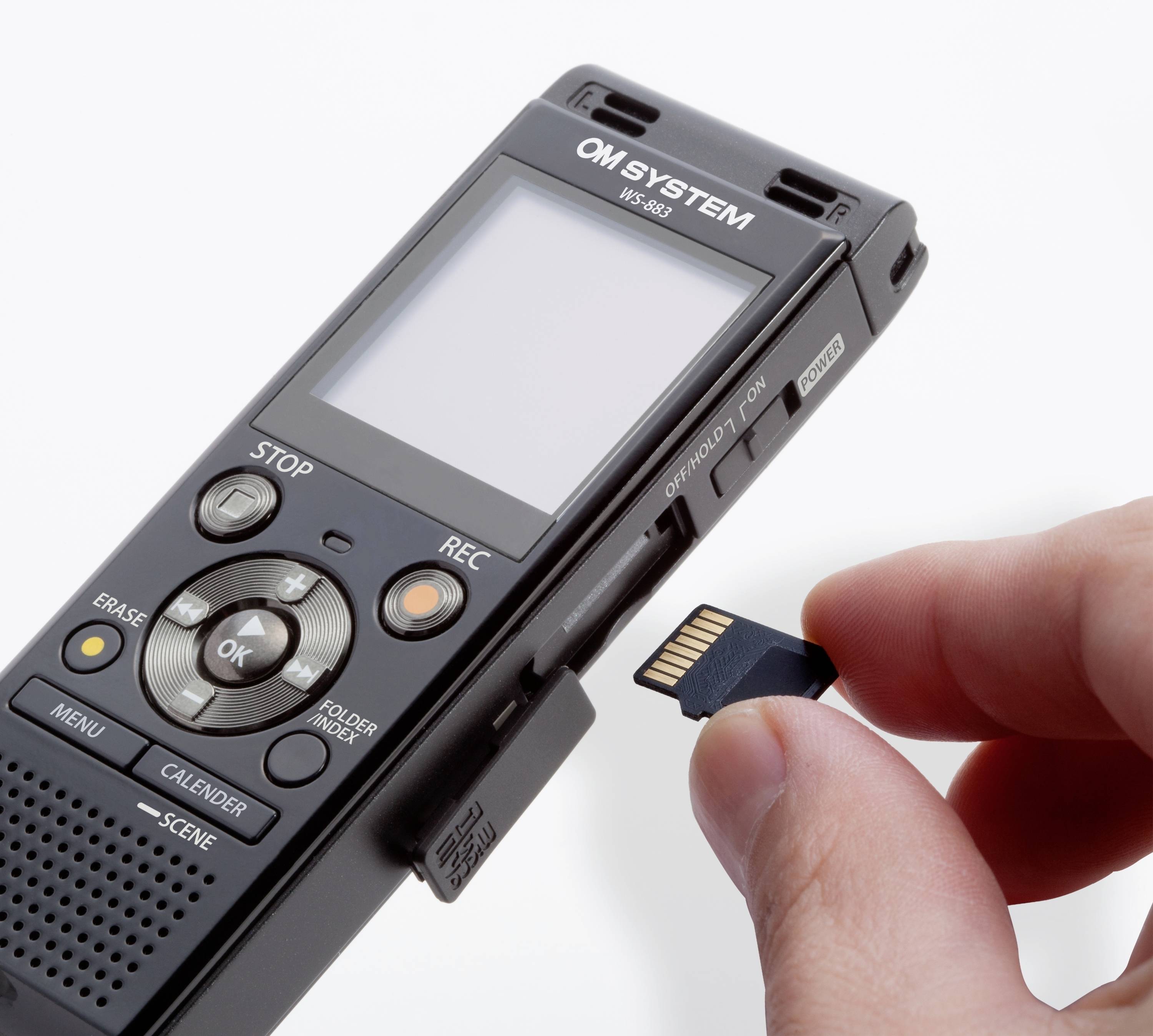 A digital voice recorder with an outstretched hand inserting a memory card into the appropriate slot.