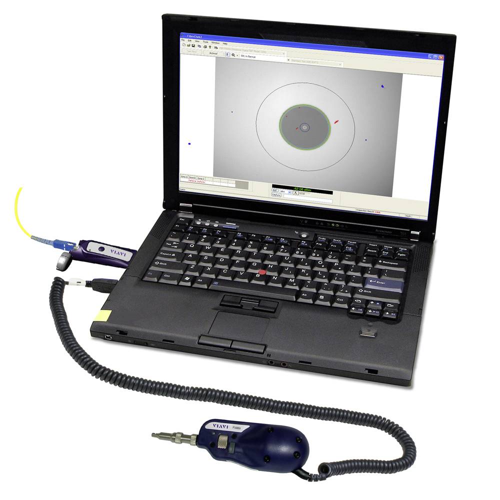 A laptop displays software for optical centring on the screen. Devices for measuring optical lenses are connected.