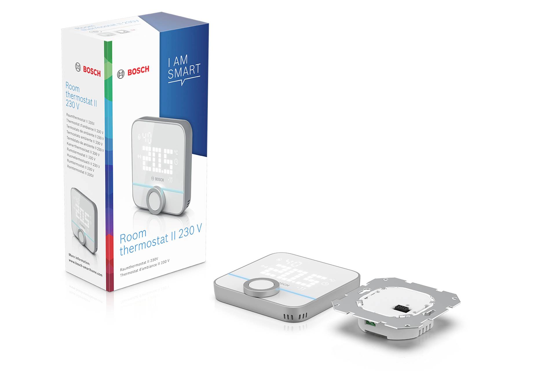 Raumthermostat mit LED-Display, Einstellungsknopf und Verpackung im Hintergrund. Text auf Verpackung: 'Room thermostat II 230 V'.