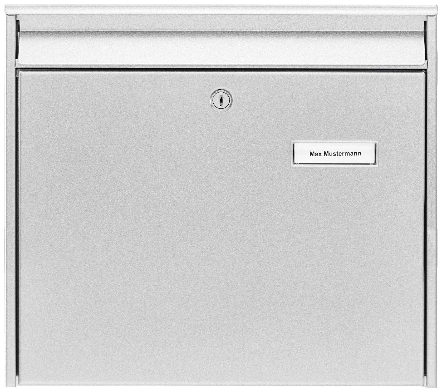 Silver letterbox with a name plate reading 'Max Mustermann', with a central lock and a letter slot at the top, set against a light background.