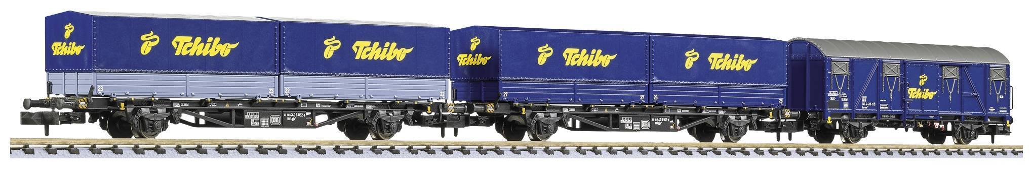 A model train with blue goods wagons, carrying 'Schöfferhofer' with a yellow logo, running on railway tracks.