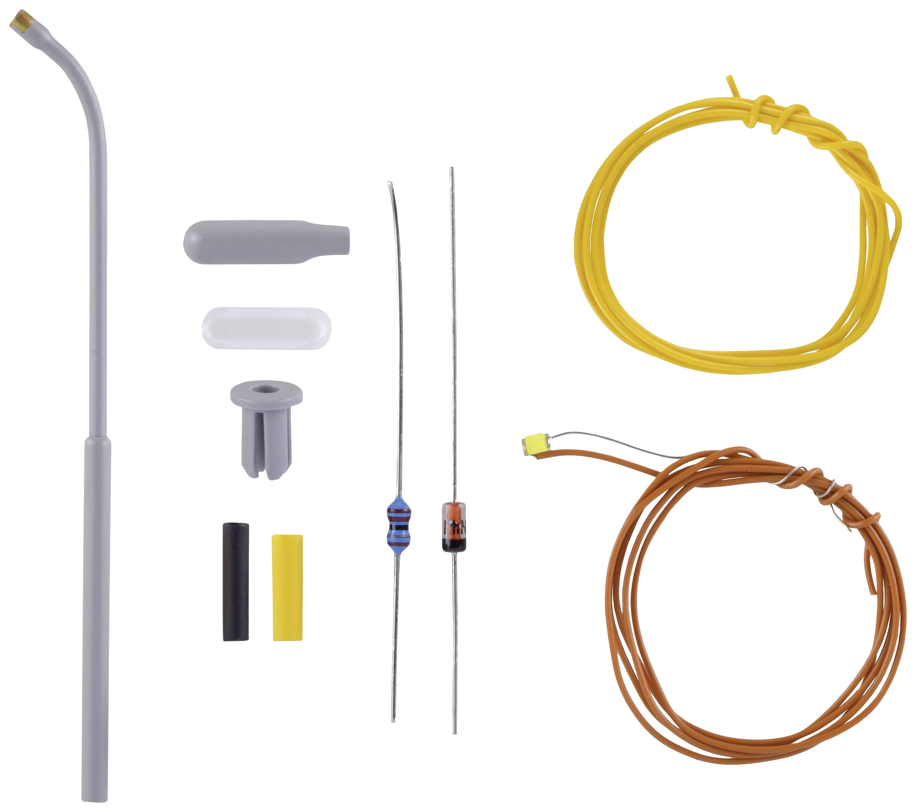 Several electronic components, including wires, a grey curved plastic tube, resistors, and plastic caps, on a white background.