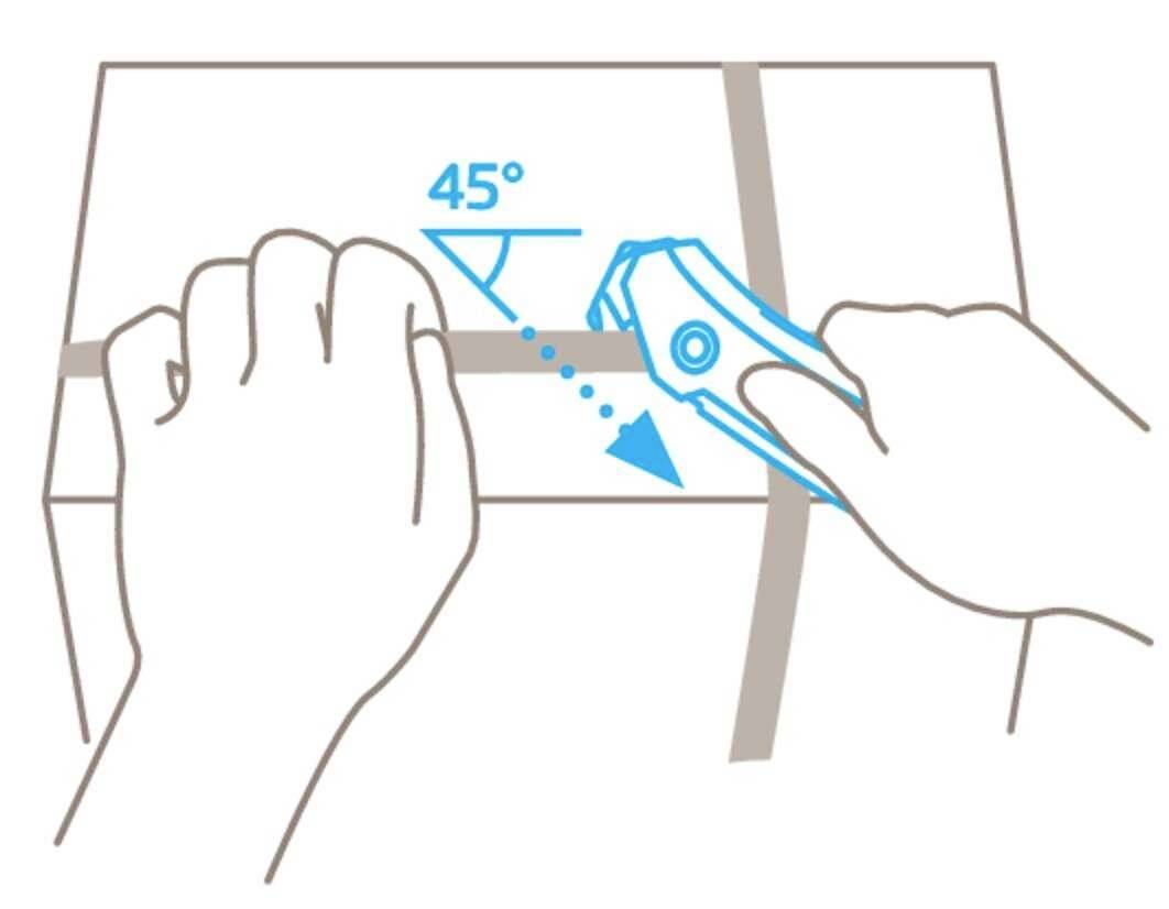 A hand holds a box cutter at a 45-degree angle to cut through adhesive tape on a cardboard box.