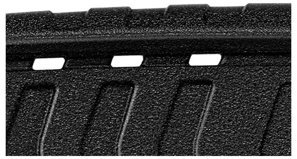 Close-up of a structured, black material with rectangular recesses along one edge.