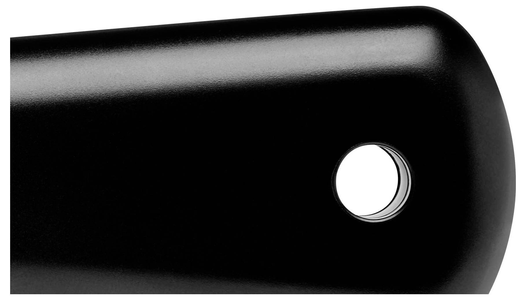 Black handle of a kitchen utensil with a round opening at the end, potentially suitable for hanging.