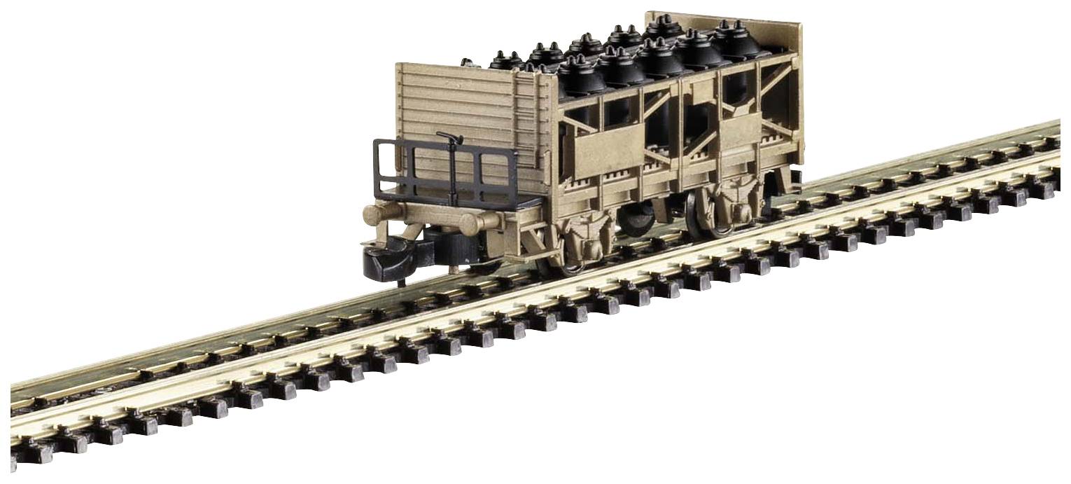 A wooden model railway wagon on a track. The wagon is transporting several black tyres.