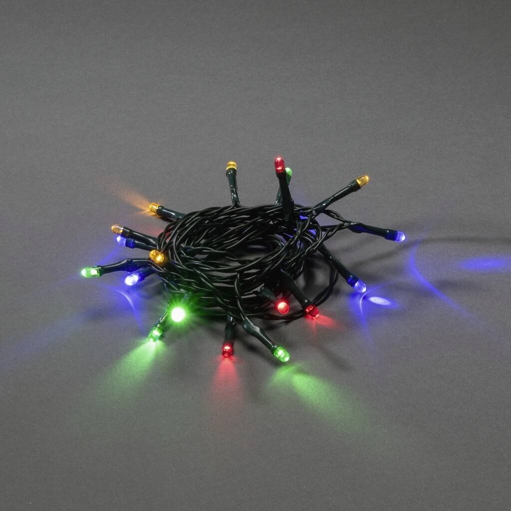 A coiled fairy light string with colourful, glowing LEDs on a grey background.
