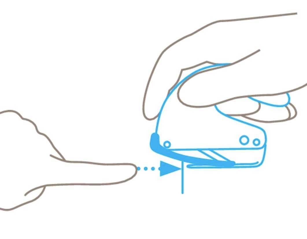 Instructions for using a small stapler: Two hands, one holding the stapler, while the other positions a stack of paper.