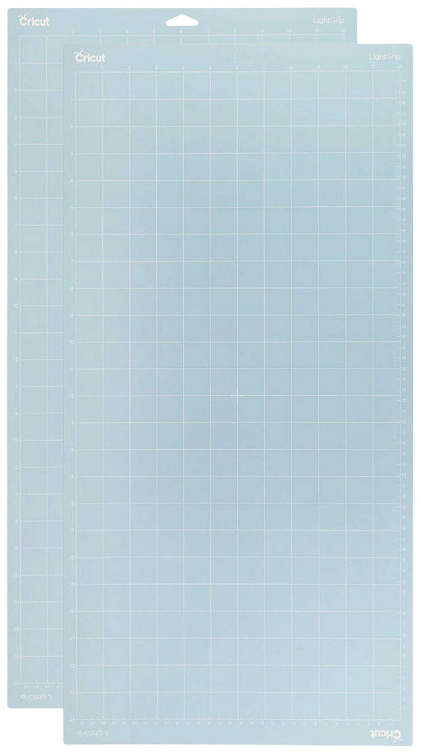 Cricut cutting mats with grid lines in various sizes, used for precise cutting of materials in craft projects.