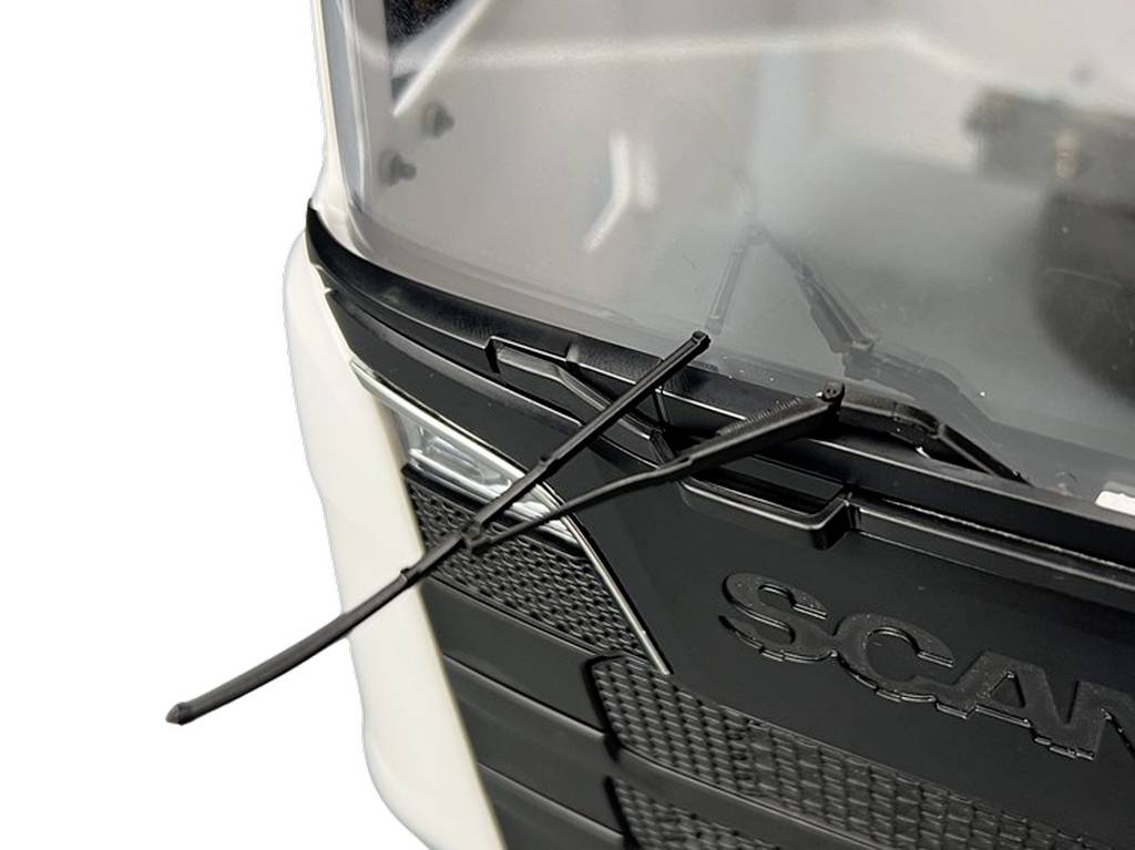 Close-up of a lorry front section in black and white with two windscreen wipers extended over the headlight.