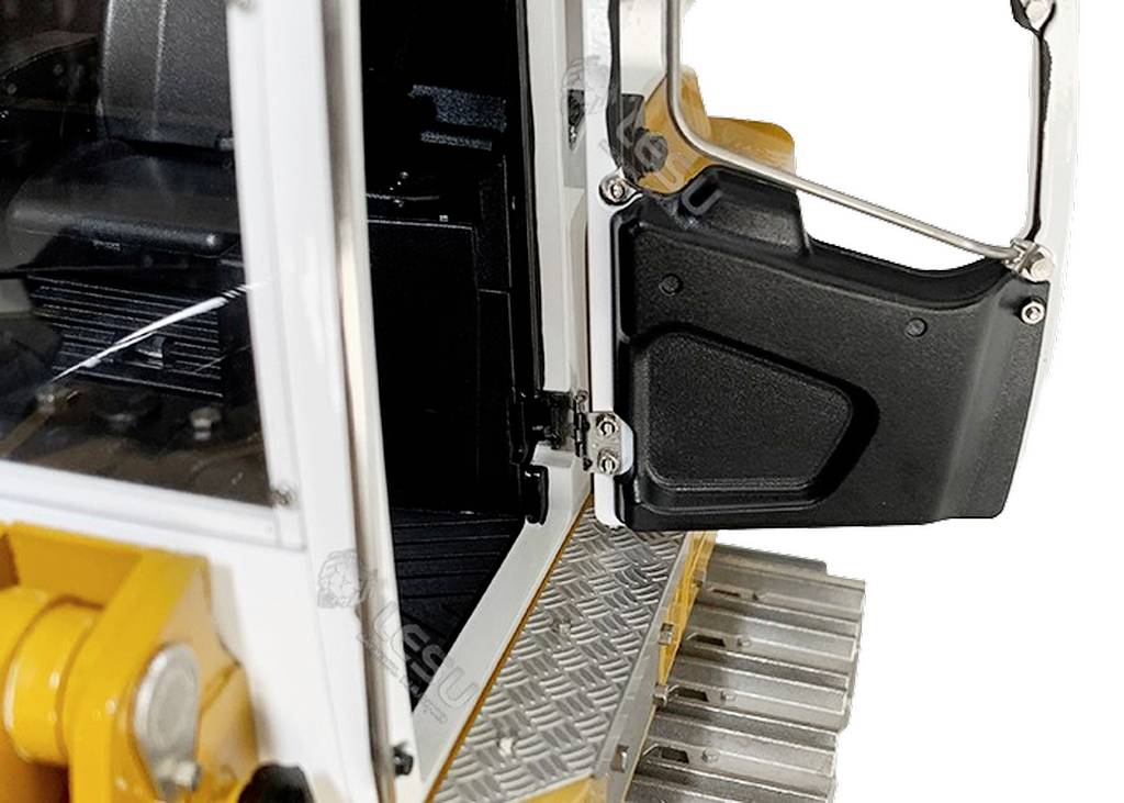 Close-up of an open door of a yellow construction trailer. The step surface is metallic and ridged. The interior and hinge are visible.