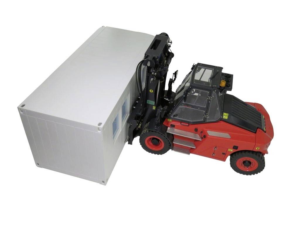 A red forklift is lifting a white container. The focus is on the forklift's hydraulic mechanisms.