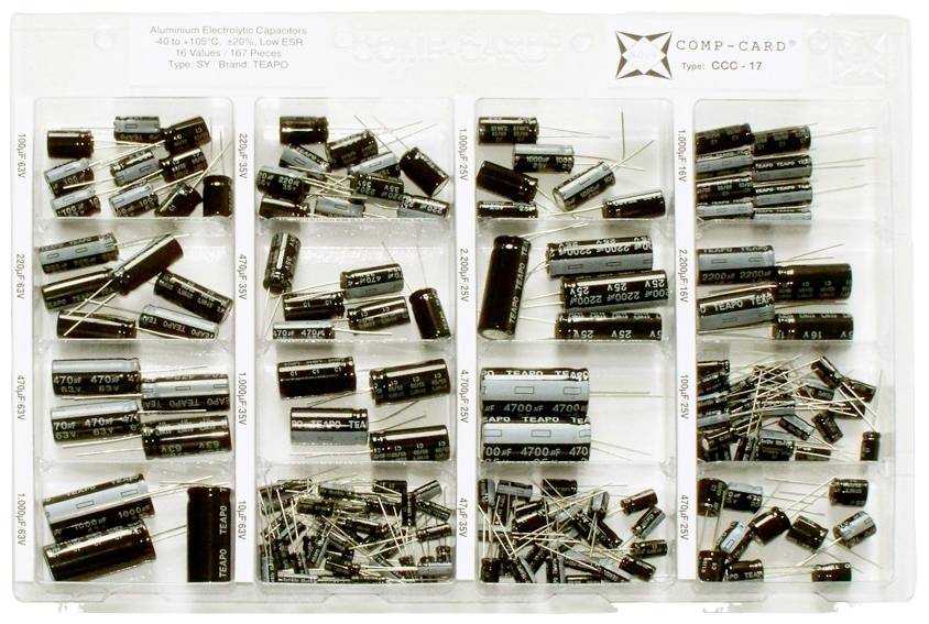 A box containing various aluminium electrolytic capacitors in organised compartments, each compartment holding capacitors of different sizes and capacities.