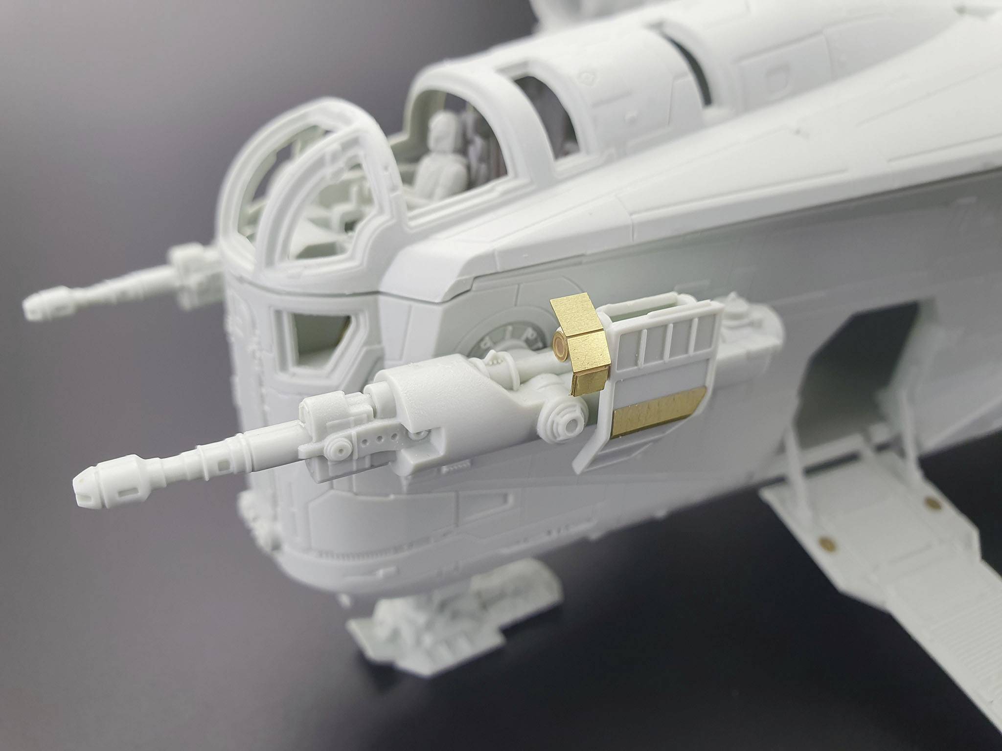 Close-up of a detailed plastic model of a futuristic aircraft with complex structures and gun barrels.