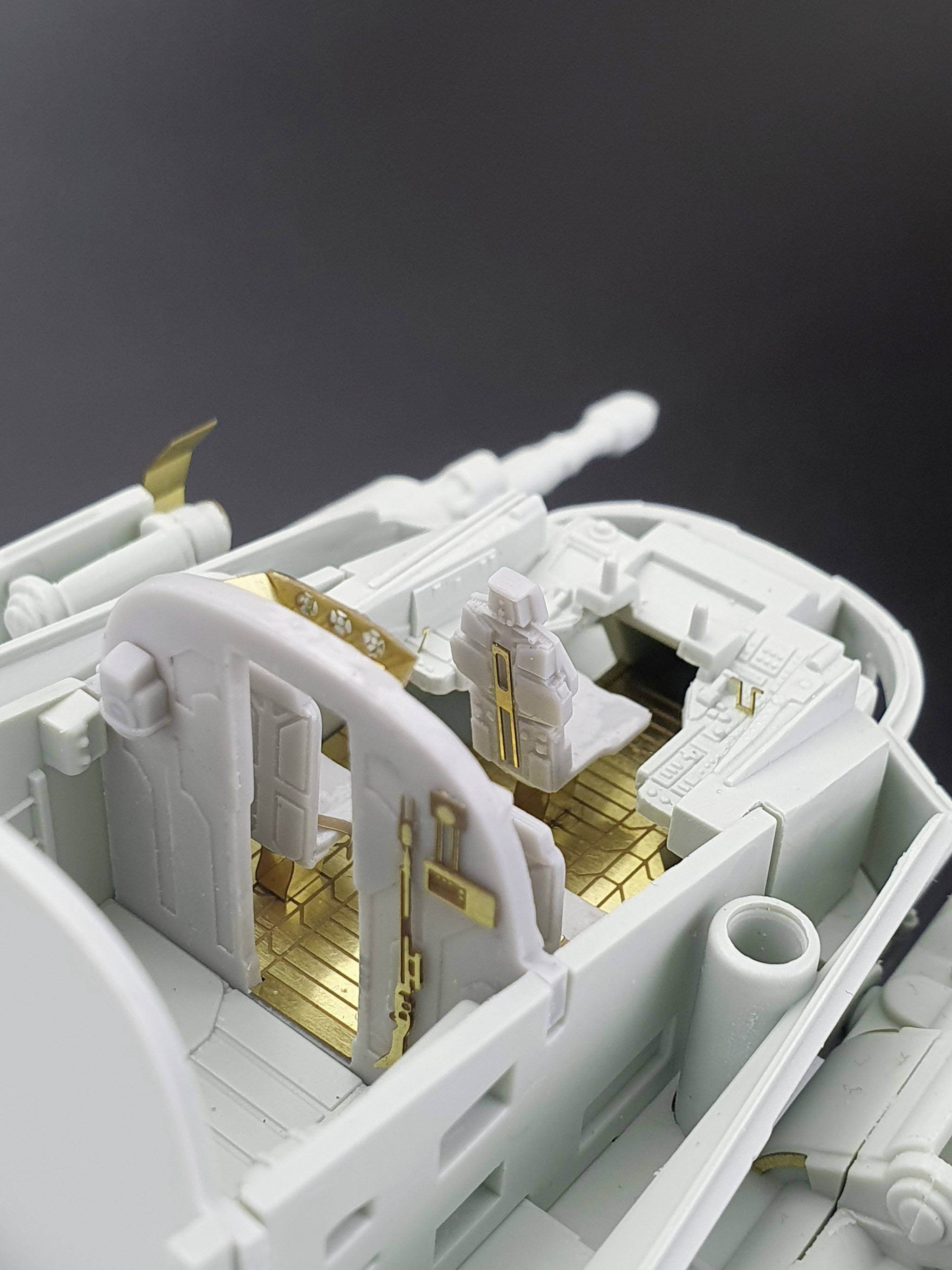 Model of a tank interior: view of the driver's seat, instruments, and golden decorations. No person on board, grey shell.