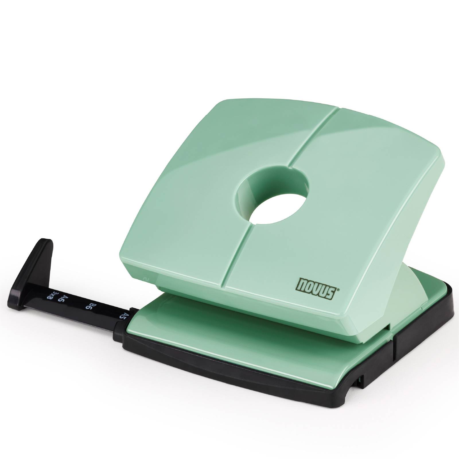 A green 'Novus' hole punch positioned against a white background, with a scale on the left side for adjusting paper size.