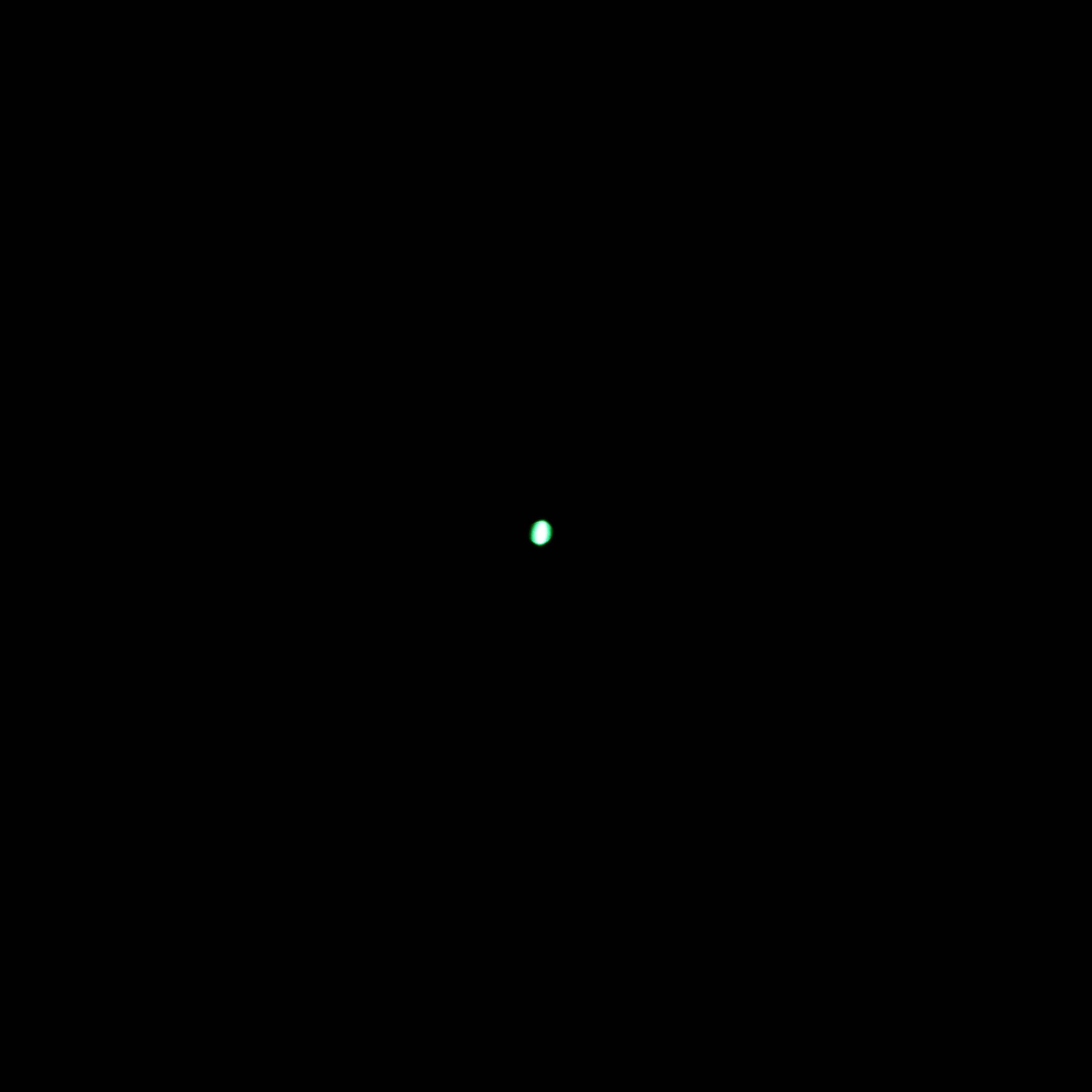 A small, luminous green light glows in the centre of a dark, black background.