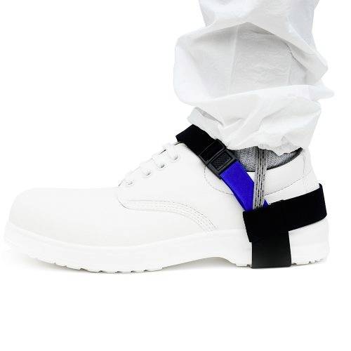 A person is wearing white safety shoes with a grounding strap around the ankle against a white background.