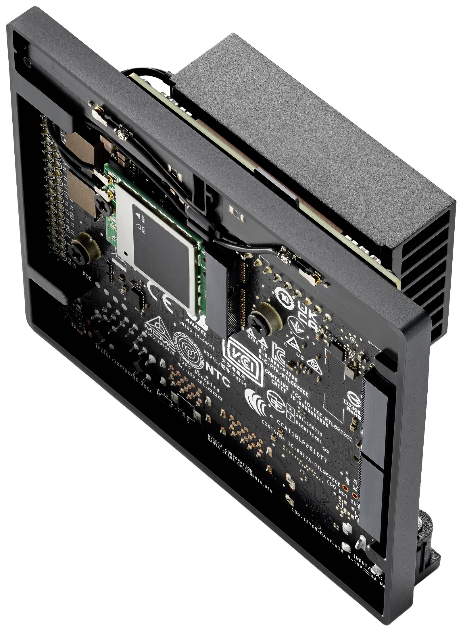 Electronic circuit board with multiple chips and components. Labels and symbols are visible. The board is mounted in a black housing.